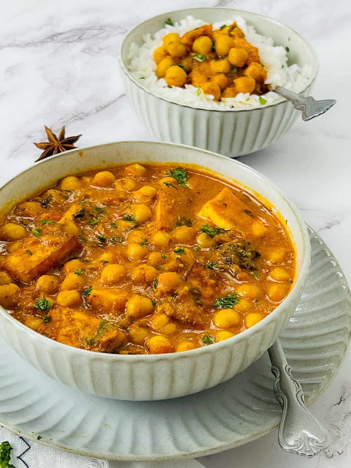 Chana paneer or chickpea spinach curry in a white bowl.