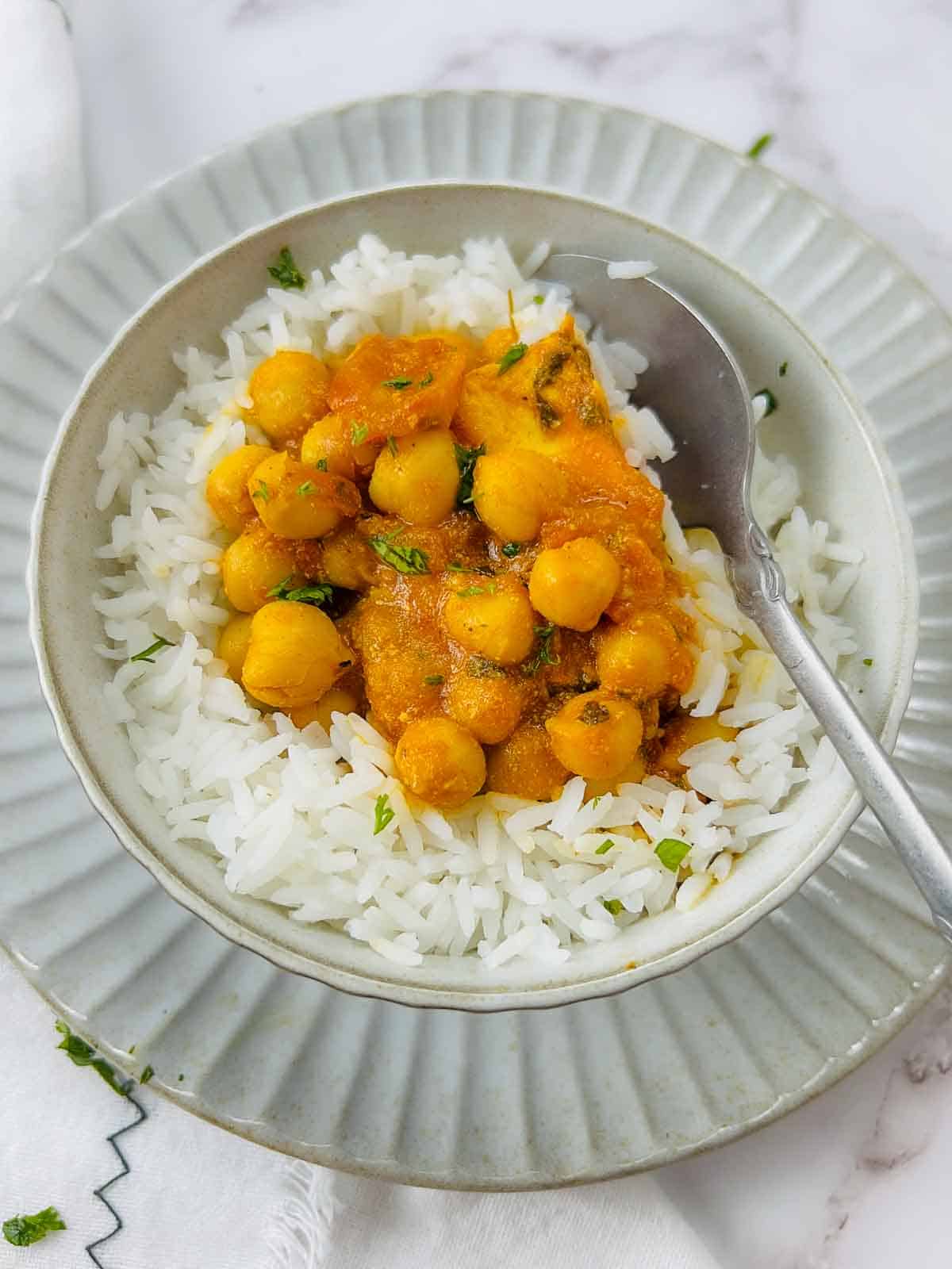 Chana paneer served on a bed of rice.