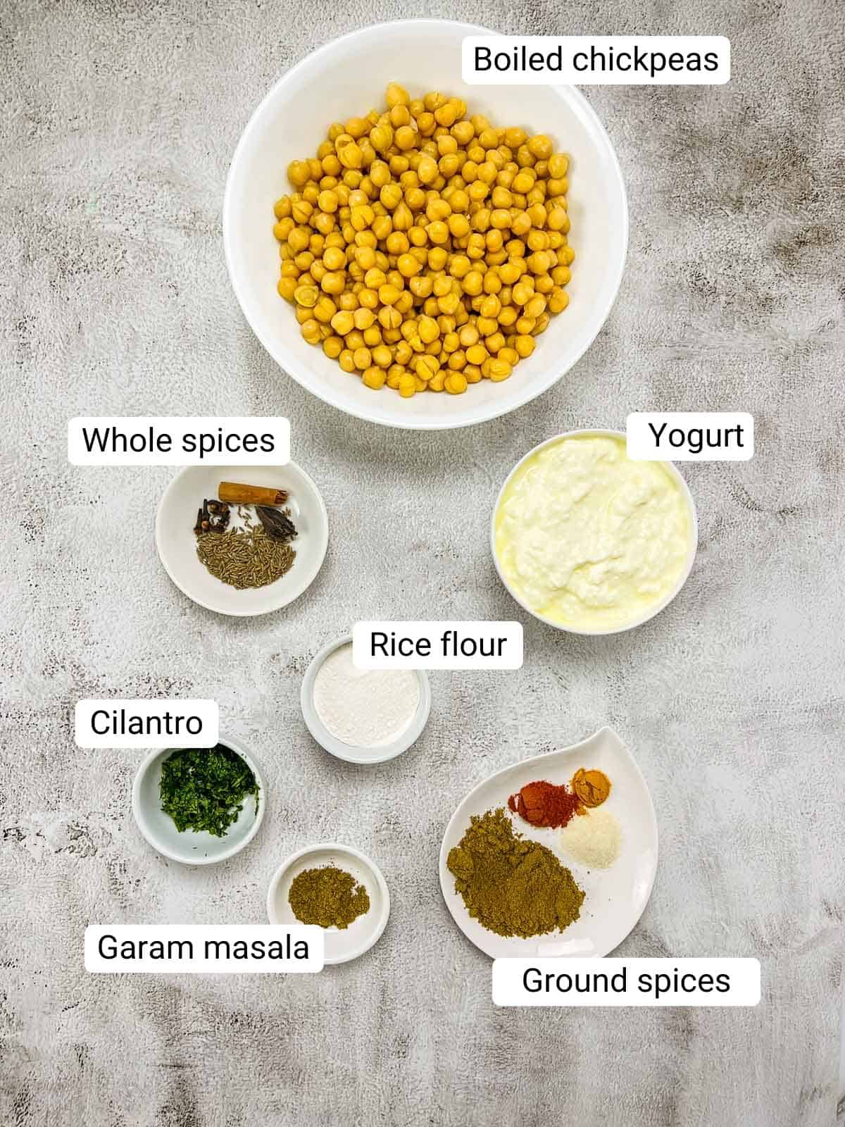 Ingredients to make chana madra placed on a grey surface.