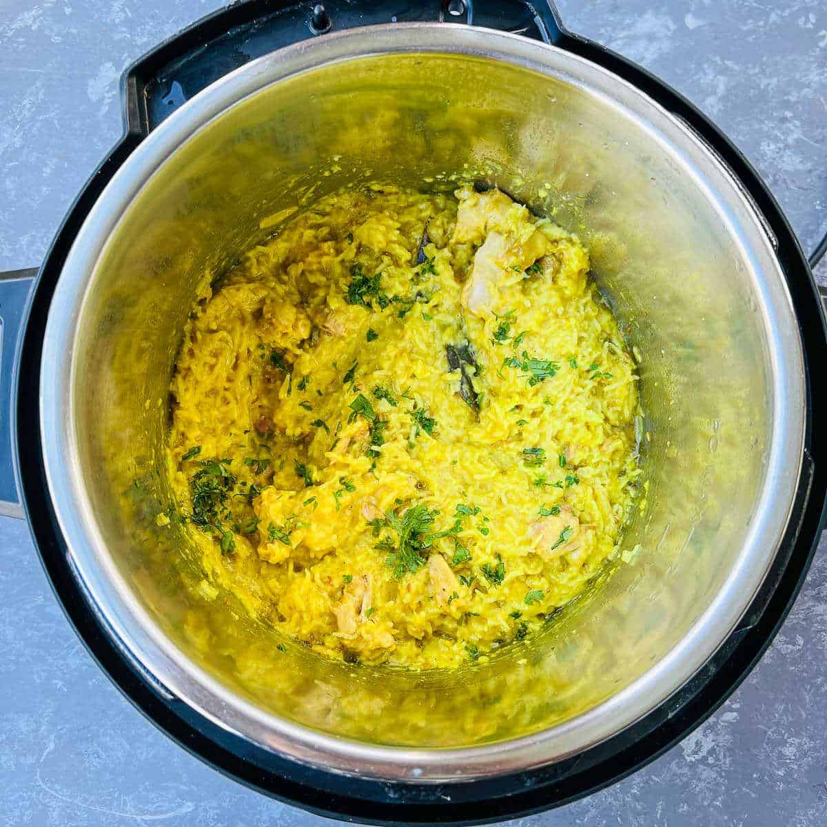 Pressure cooked chicken khichdi with cilantro garnish in the Instant Pot.
