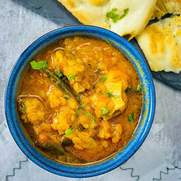 Chicken red lentil curry in blue bowl.