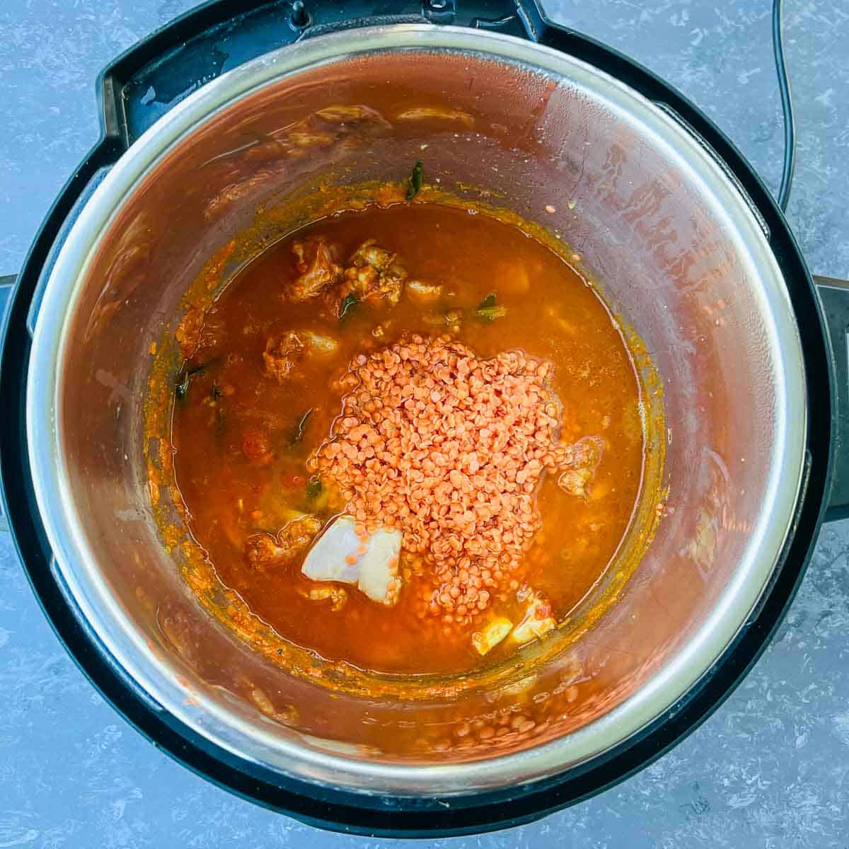 Red lentils and water added in the Instant Pot.