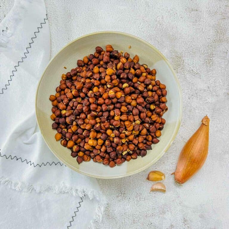 Cooked black chickpeas in a brown bowl.