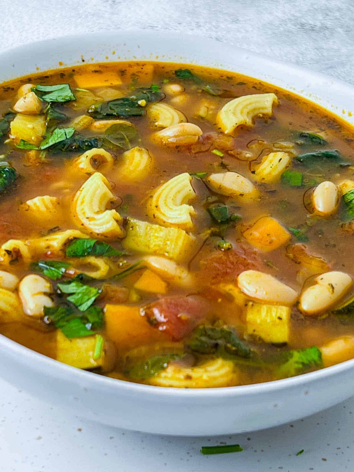Minestrone soup garnished with fresh parsley.
