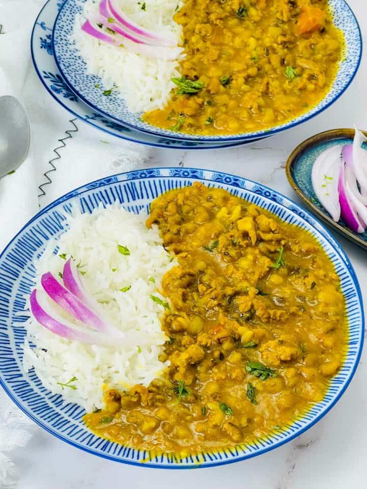 Two plates of keema green moong curry with rice.