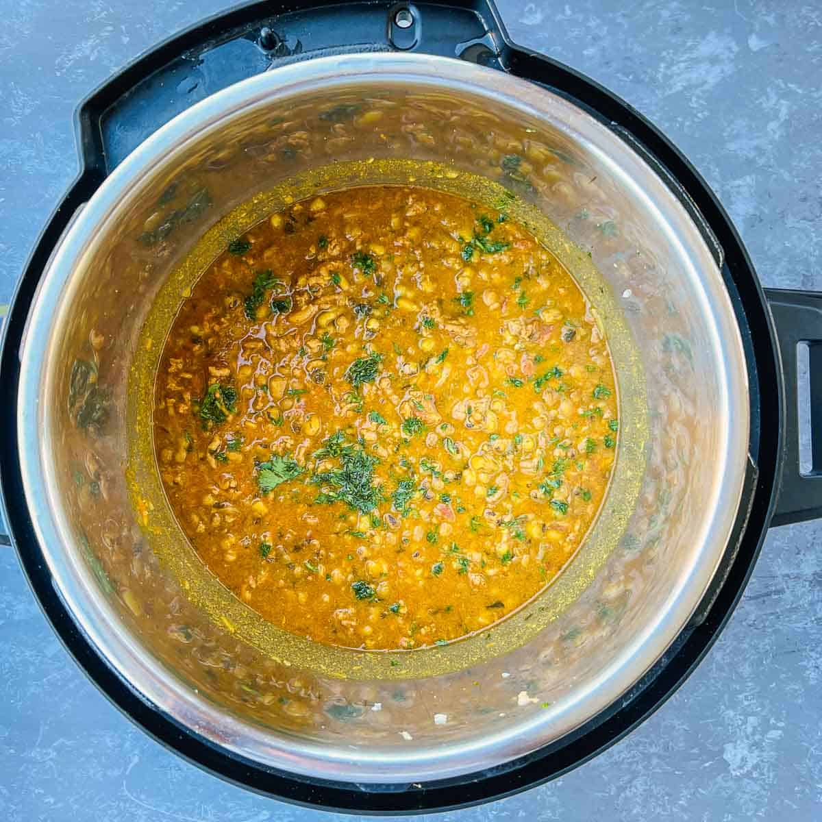 Pressure cooked keema green moong dal garnished with cilantro in Instant Pot.