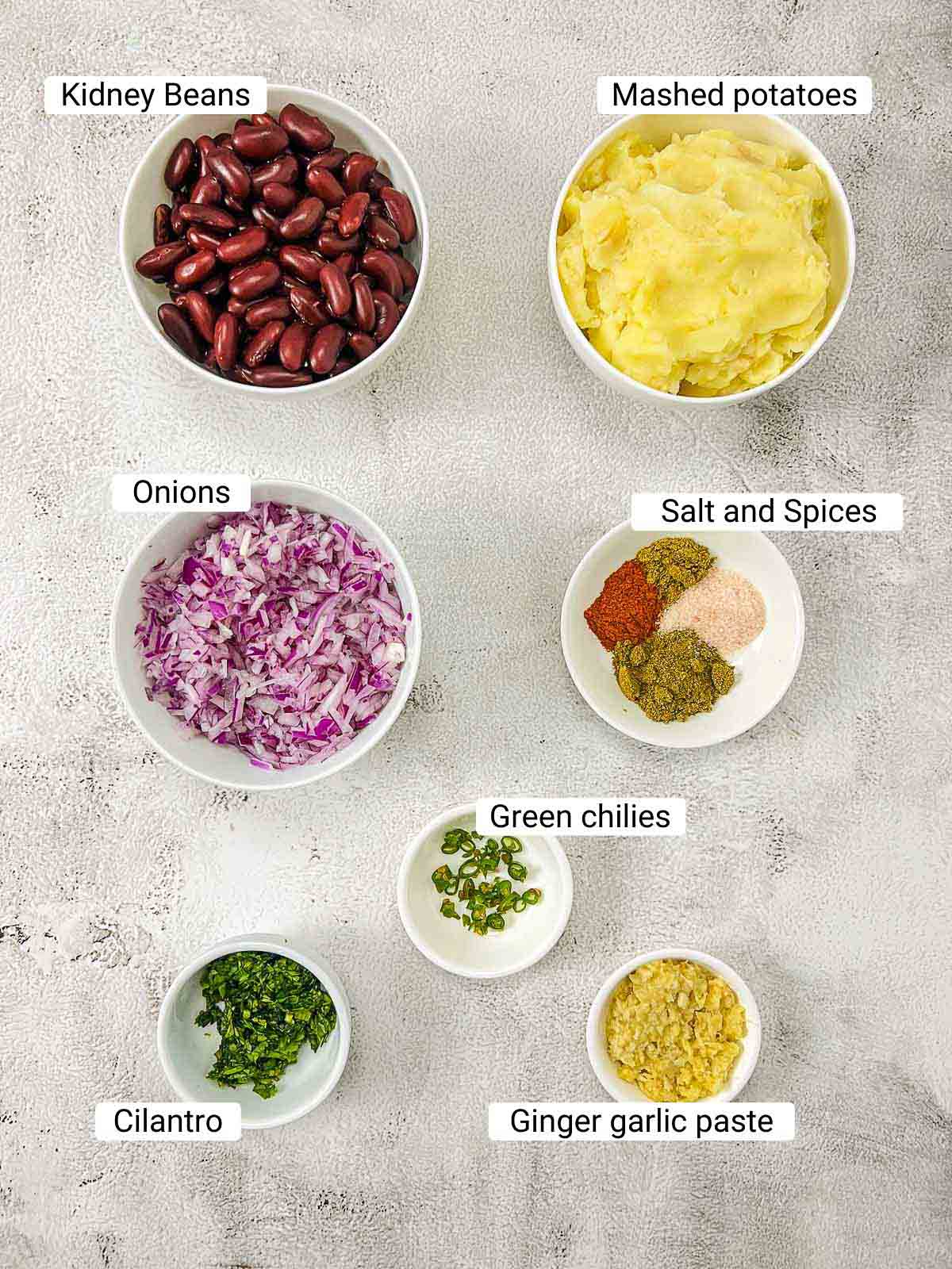 Ingredients to make kidney bean patties on a white surface.