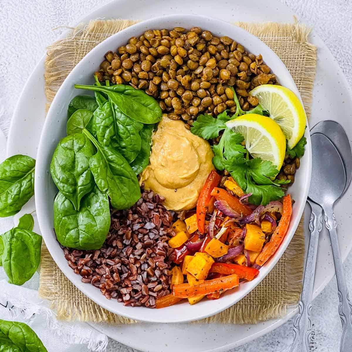 Lentil buddha bowl with fresh spinach in the background.