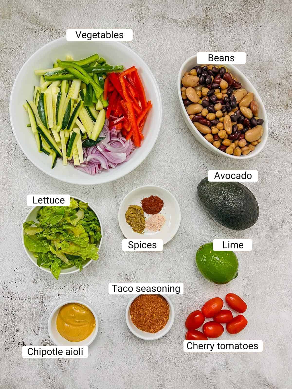 Ingredients to make taco Buddha bowl on a white surface.