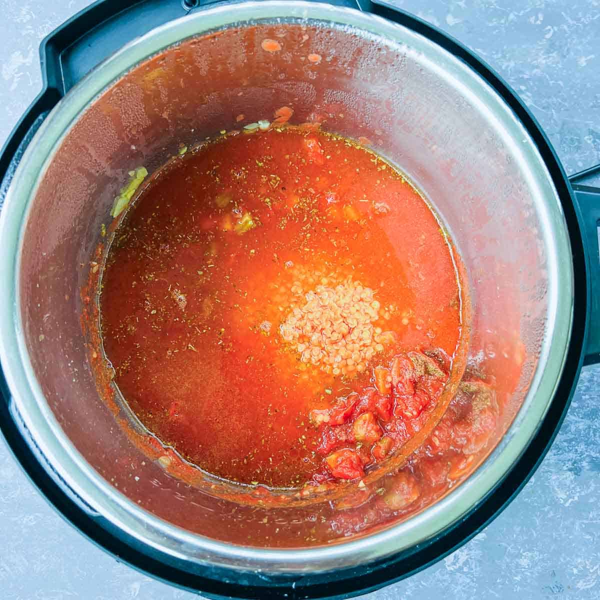 Tomatoes, lentils, spices, and stock added to the Instant Pot.