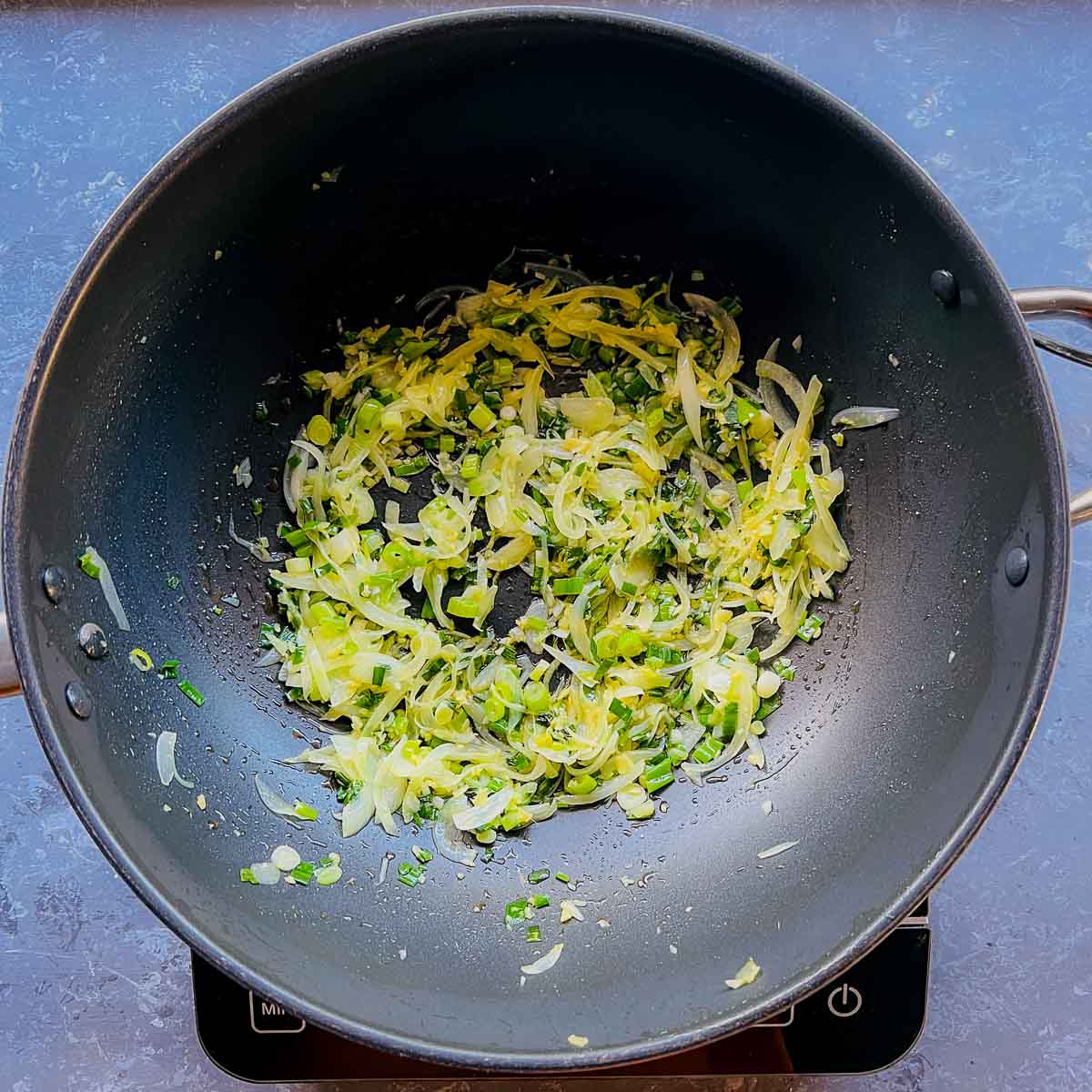 Sauted onion, ginger, garlic, and scallion in a large frying pan.