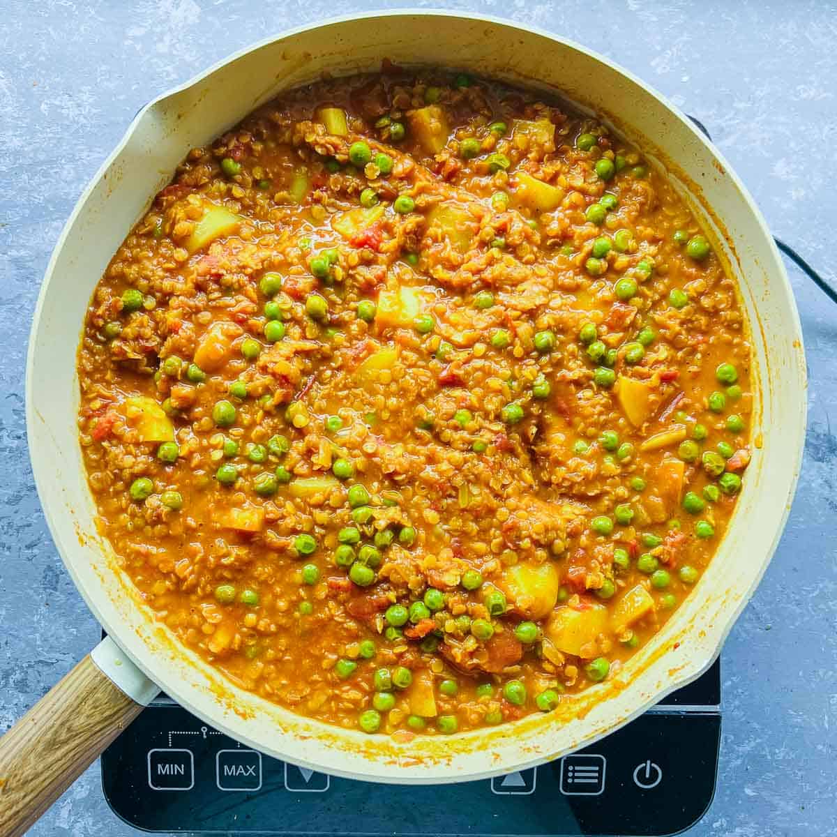 Fully cooked lentil peas potato curry in the frying pan.