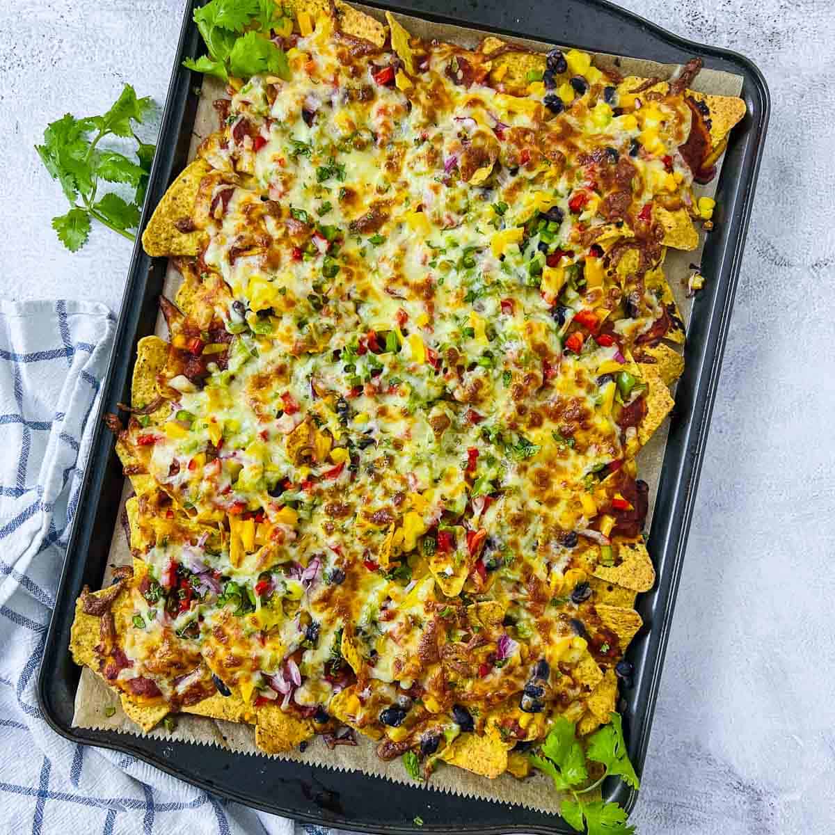 Baked loaded nachos on a white surface.