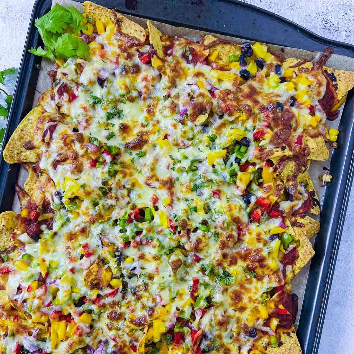 Loaded nachos after baking with cheese melted and slightly golden brown.