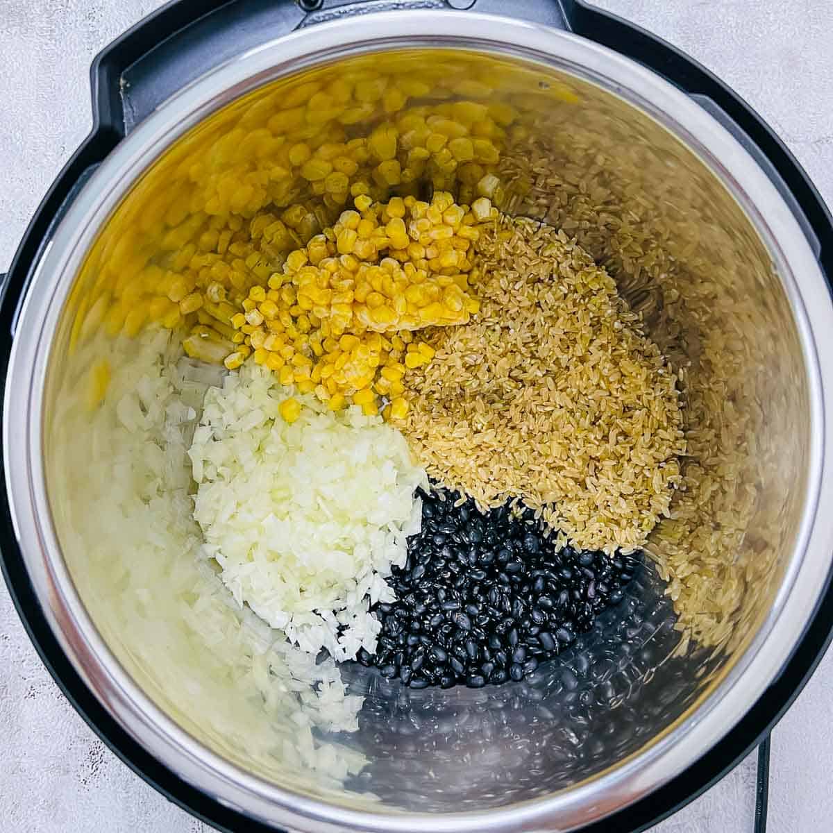 Brown rice, black beans, onion, and corn in Instant Pot.