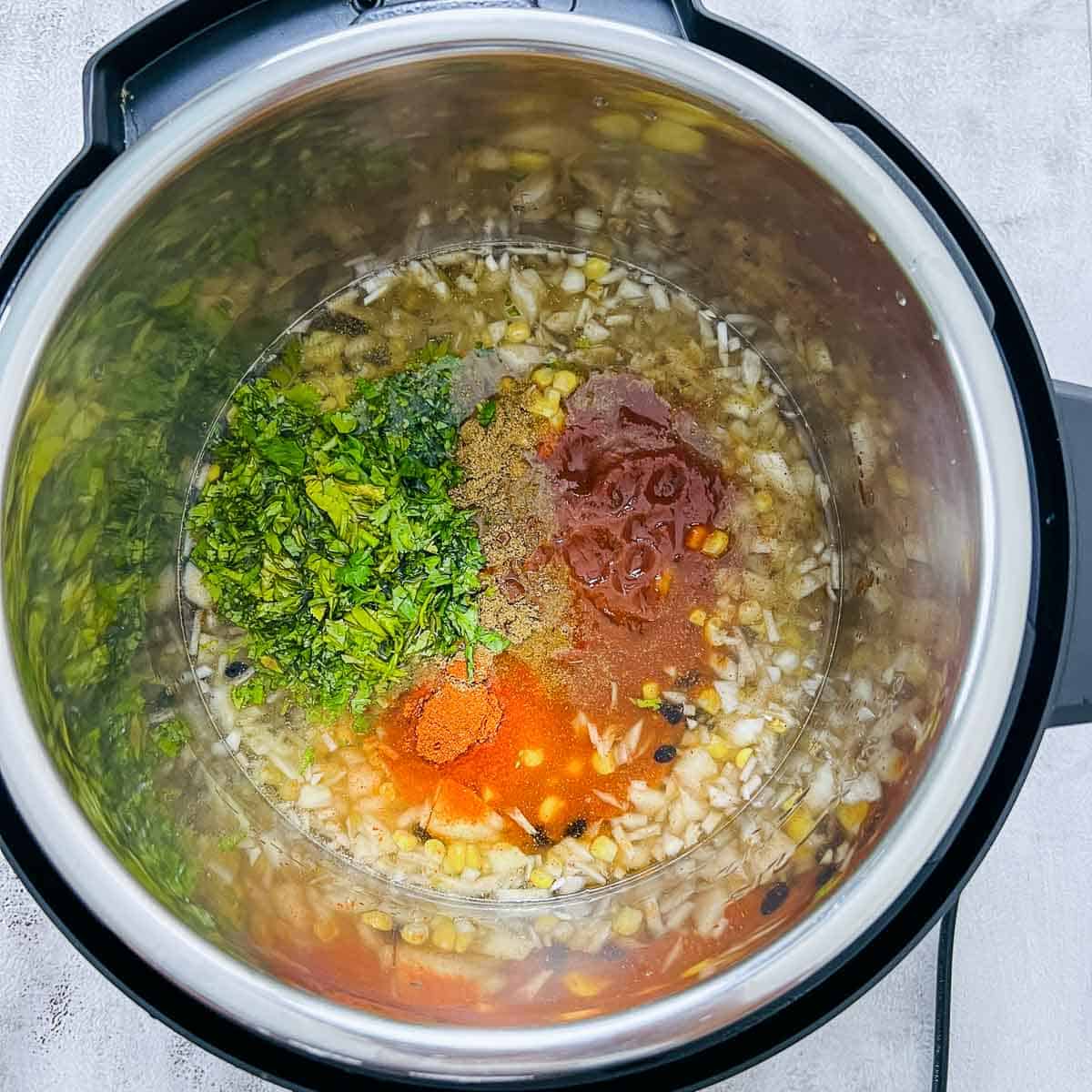 Spices, salsa, and cilantro in Instant Pot.