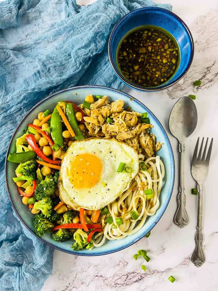 Chicken and chickpea udon noodle bowl served with dipping sauce.