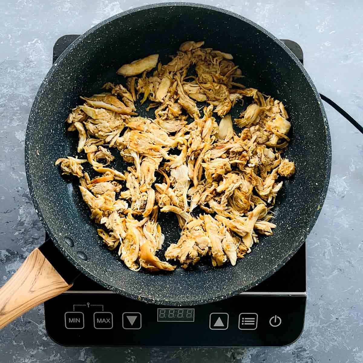 Marinated chicken sauted in a frying pan.