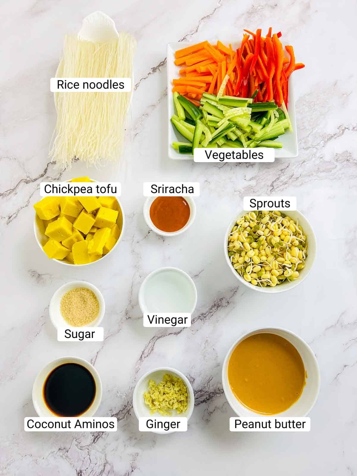 Ingredients to make the chickpea tofu Buddha bowl placed on a marble surface.