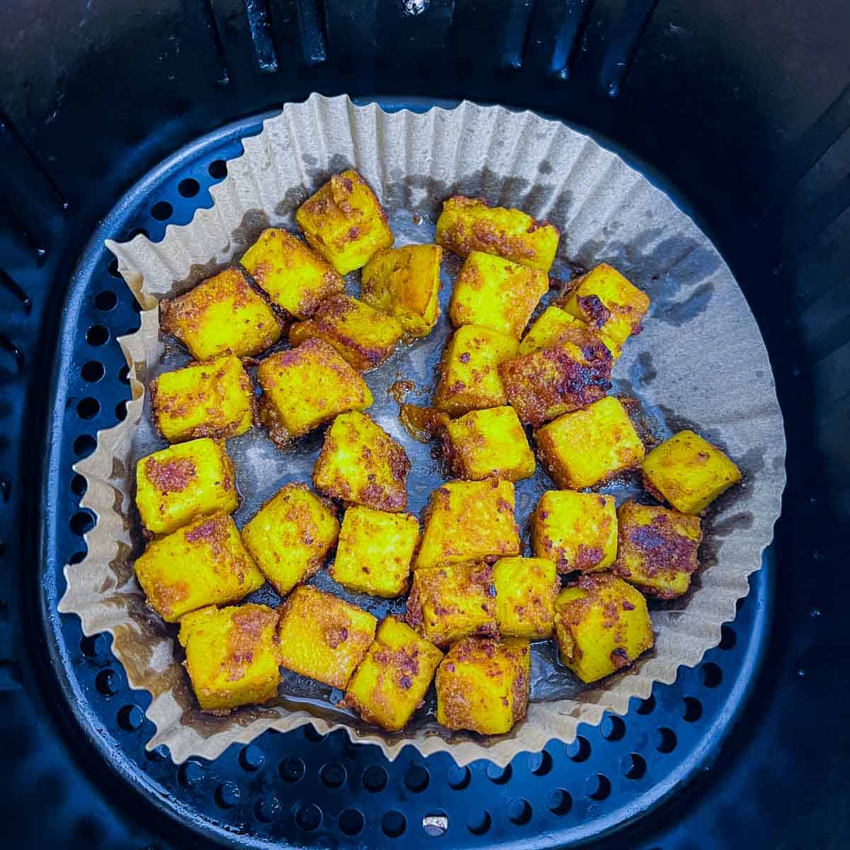 Roasted chickpea tofu in air fryer basket.