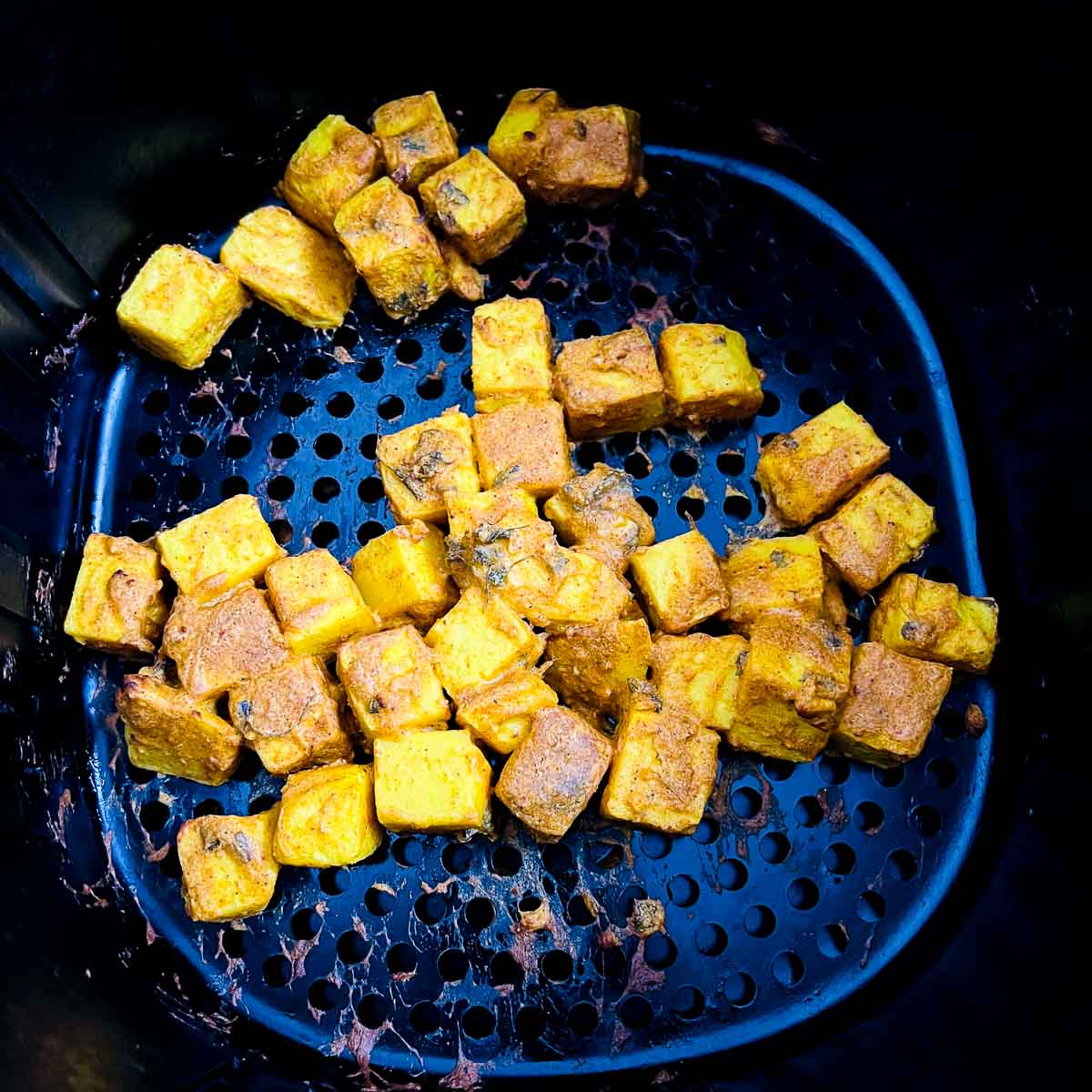 Roasted chickpea tofu tikka in air fryer basket.