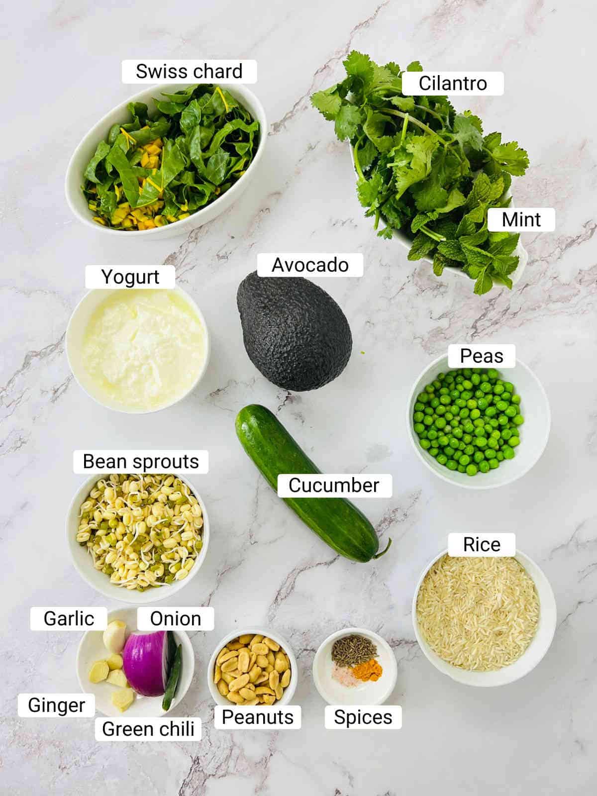 Ingredients to make green goddess power bowl on a white surface.