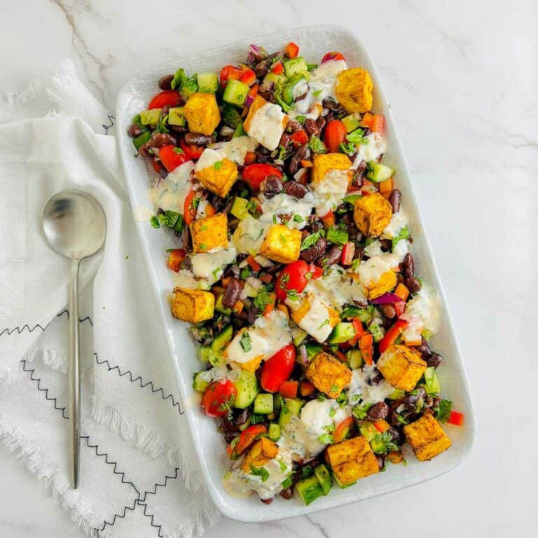 Paneer rajma salad on a white plate with a spoon in the side.
