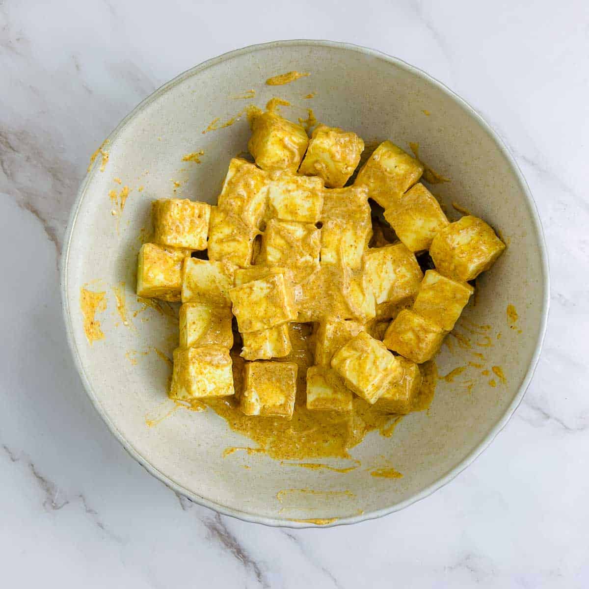 Marinated paneer in a brown bowl.