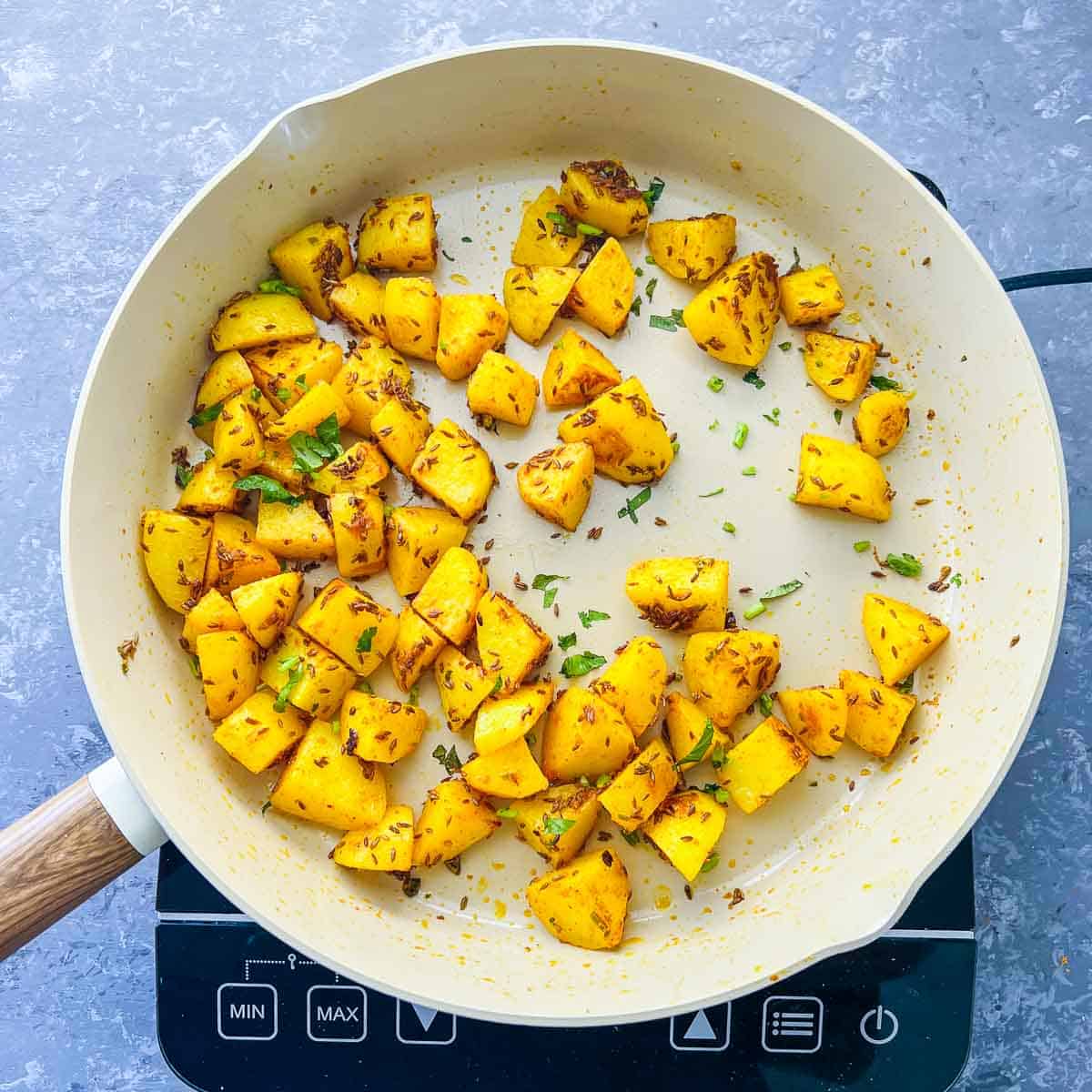 Potatoes cooked in frying pan.