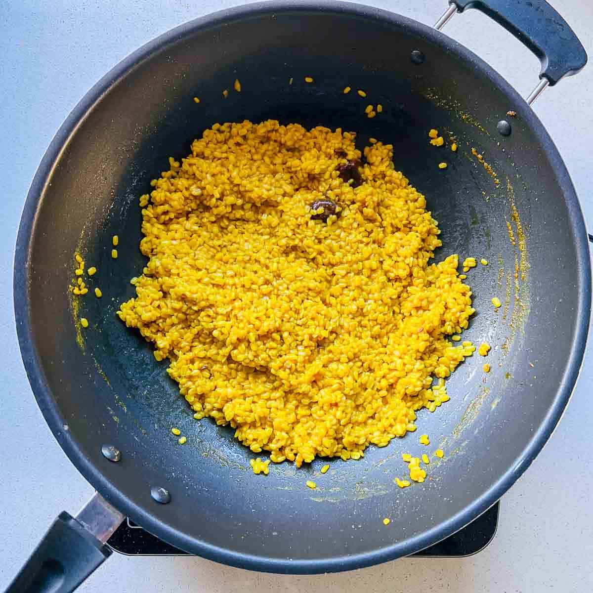 Cooked yellow lentils in frying pan.