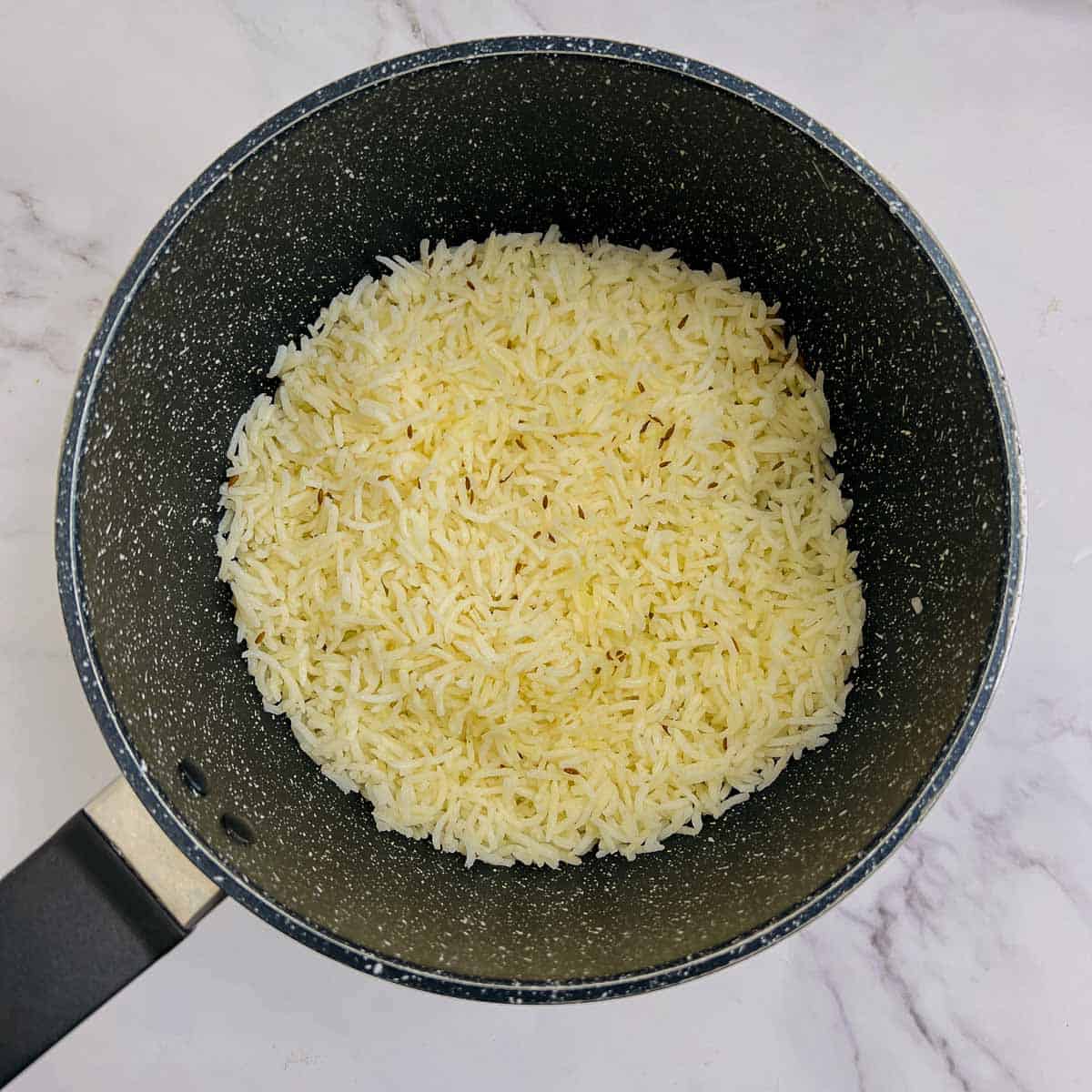 Jeera rice in a small saucepan.