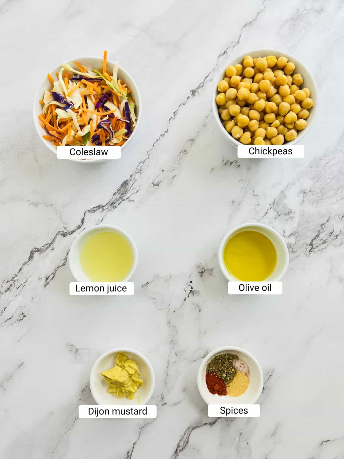Ingredients to make chickpea crunch salad on a marble surface.