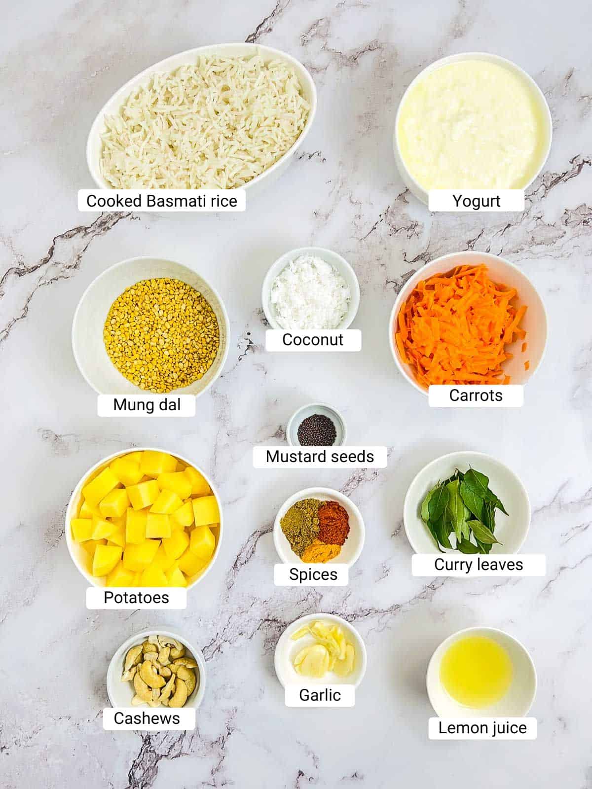 Ingredients to make curd rice bowl on a white surface.