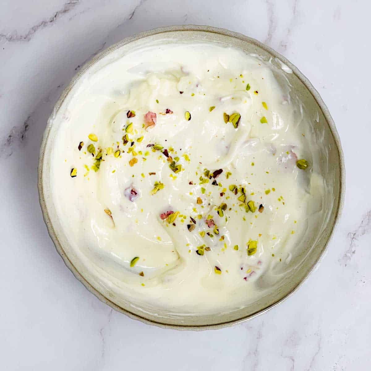 Rose shrikhand in a white bowl.