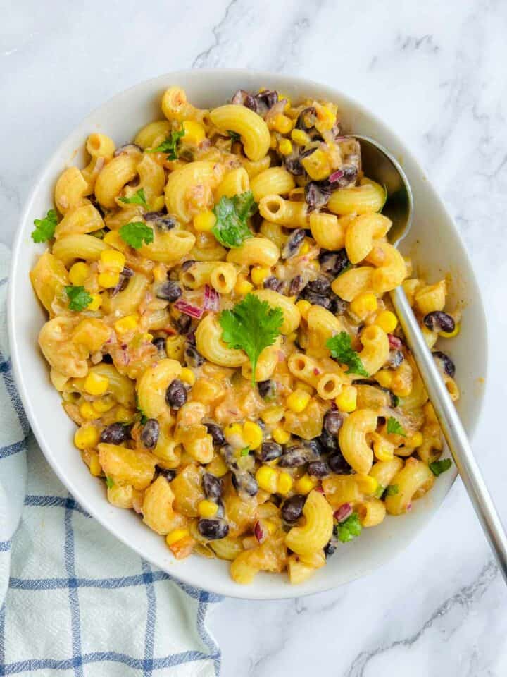 Mexican macaroni salad with black beans in a white bowl.