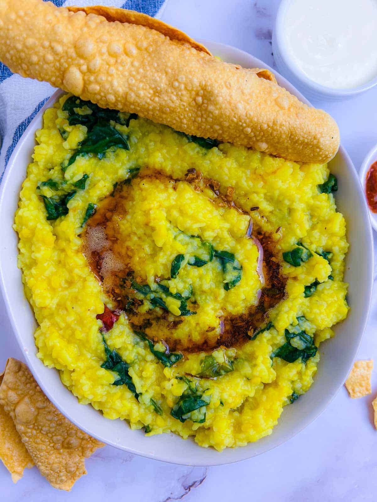 Khichdi served in a bowl with tadka on the top.