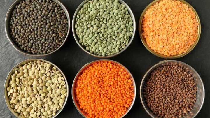 Different types of lentils in small bowls.