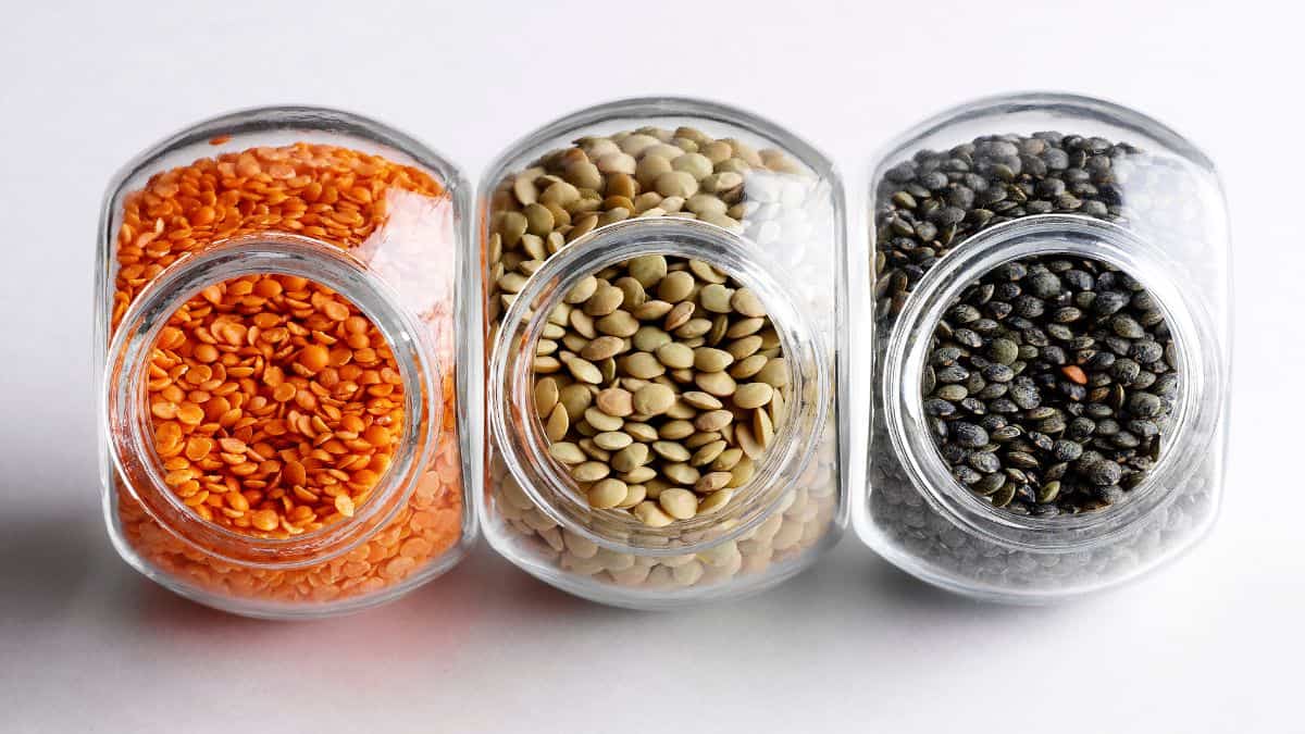 Different types of lentils in jars without the lid.