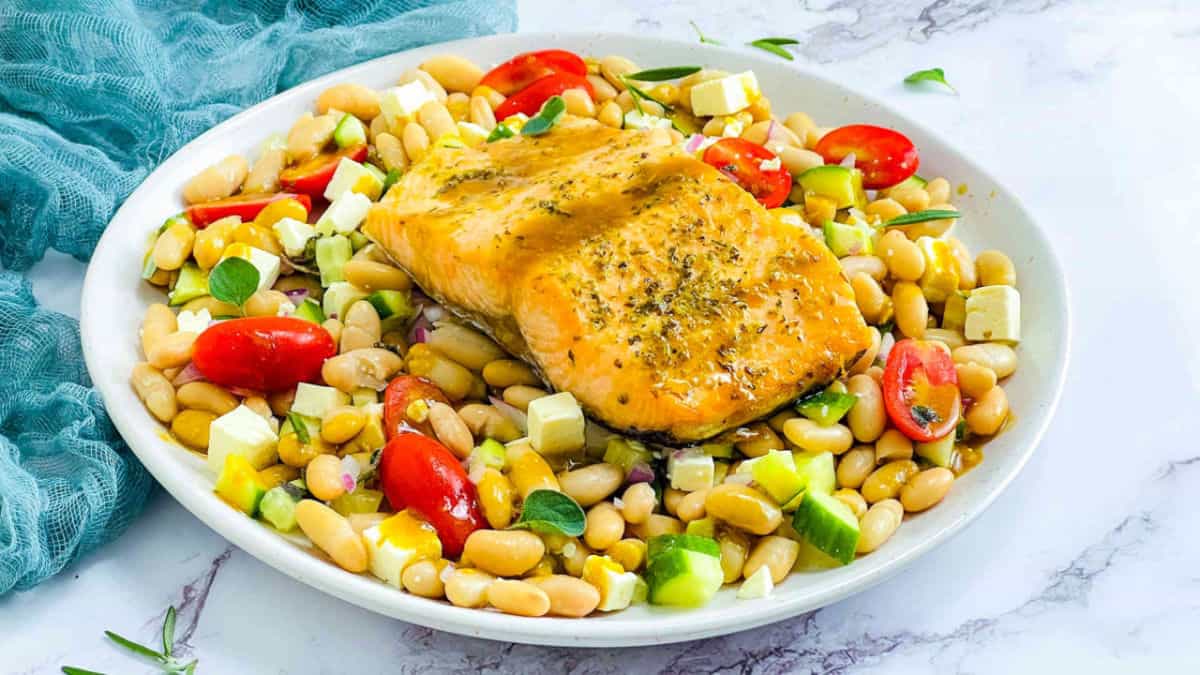 Salmon and white bean salad on a white plate.