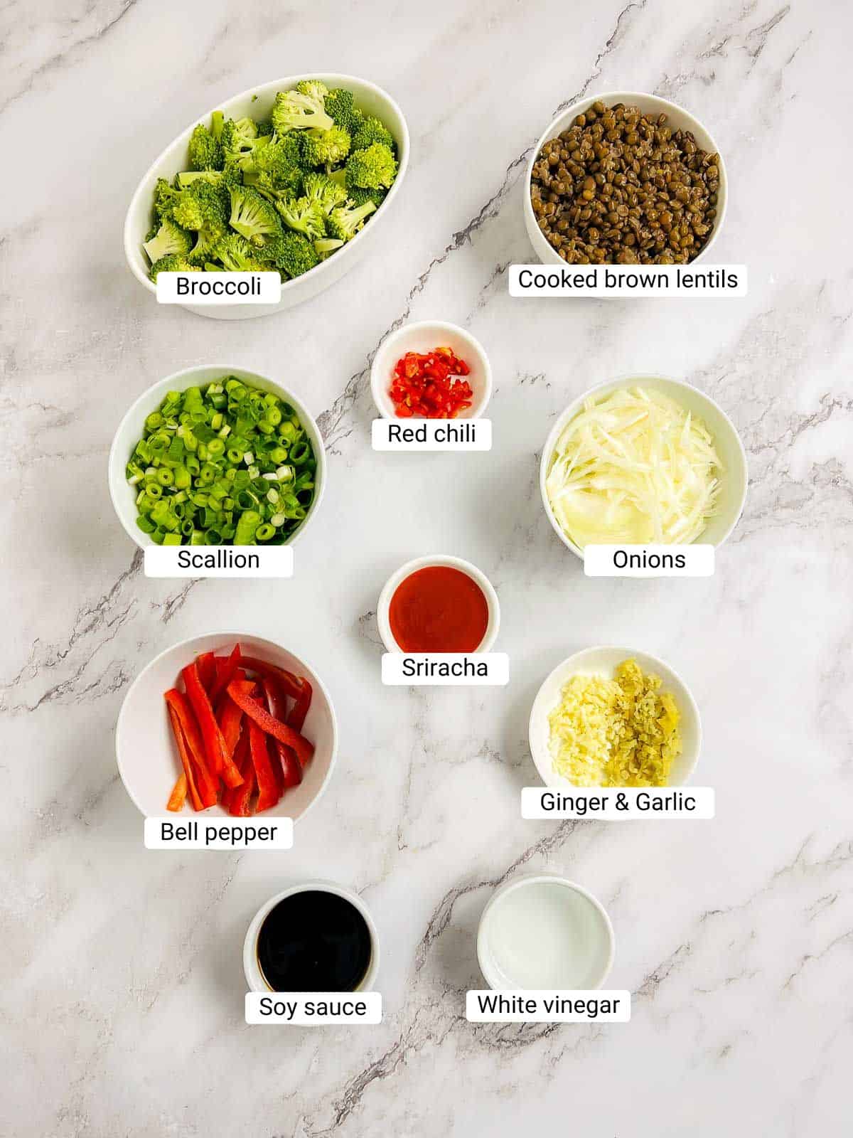 Ingredients to make broccoli lentil stir fry on a marble surface.