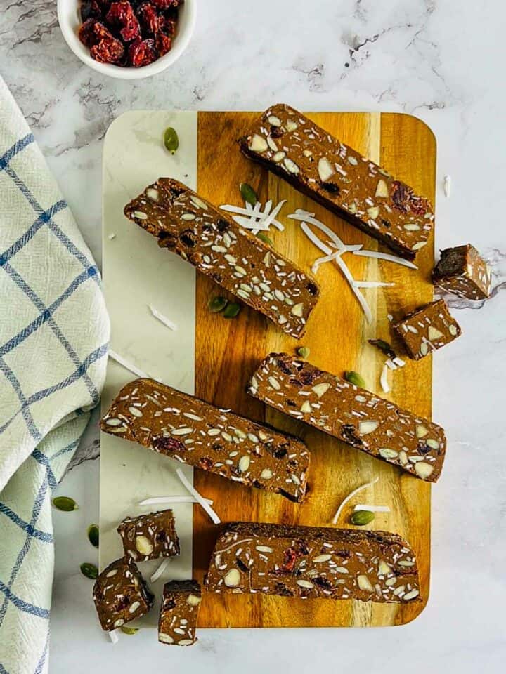Lentil energy bars topped with shredded coconut and dried cranberries in the background.