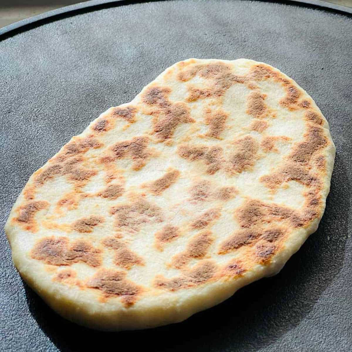 Flipped naan to cook both sides.