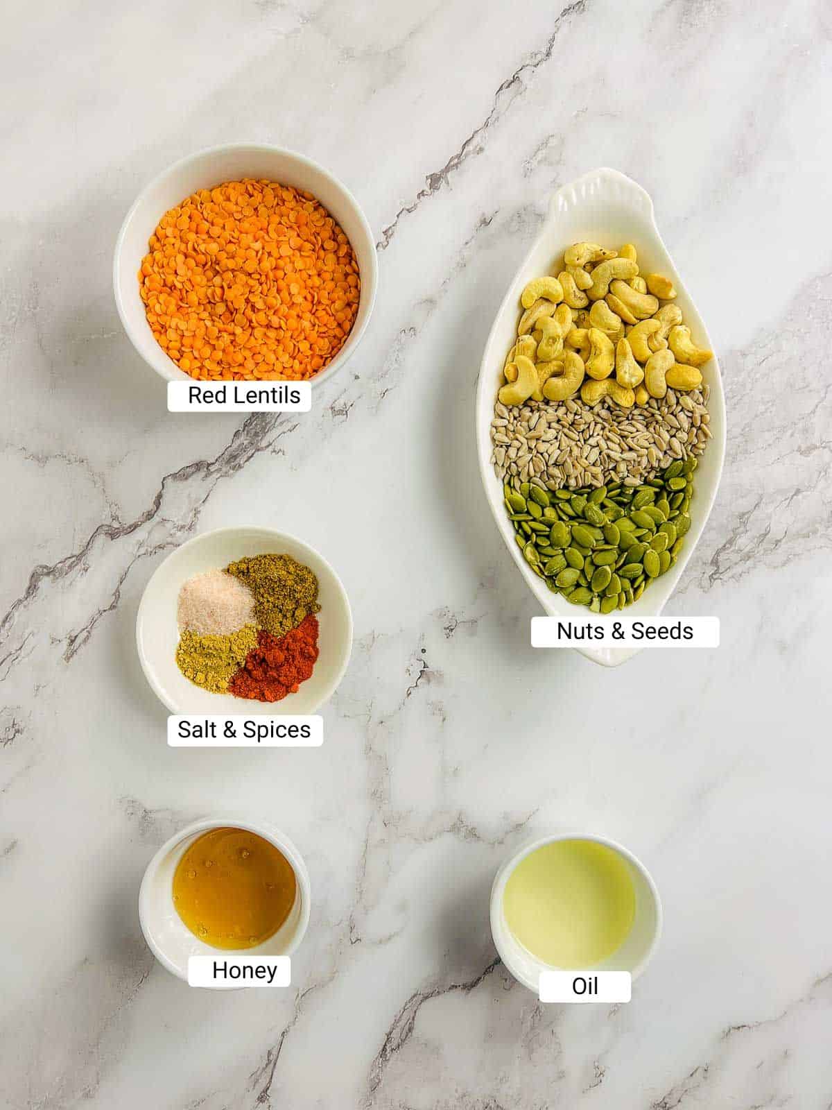 Ingredients to make red lentil granola on a marble surface.