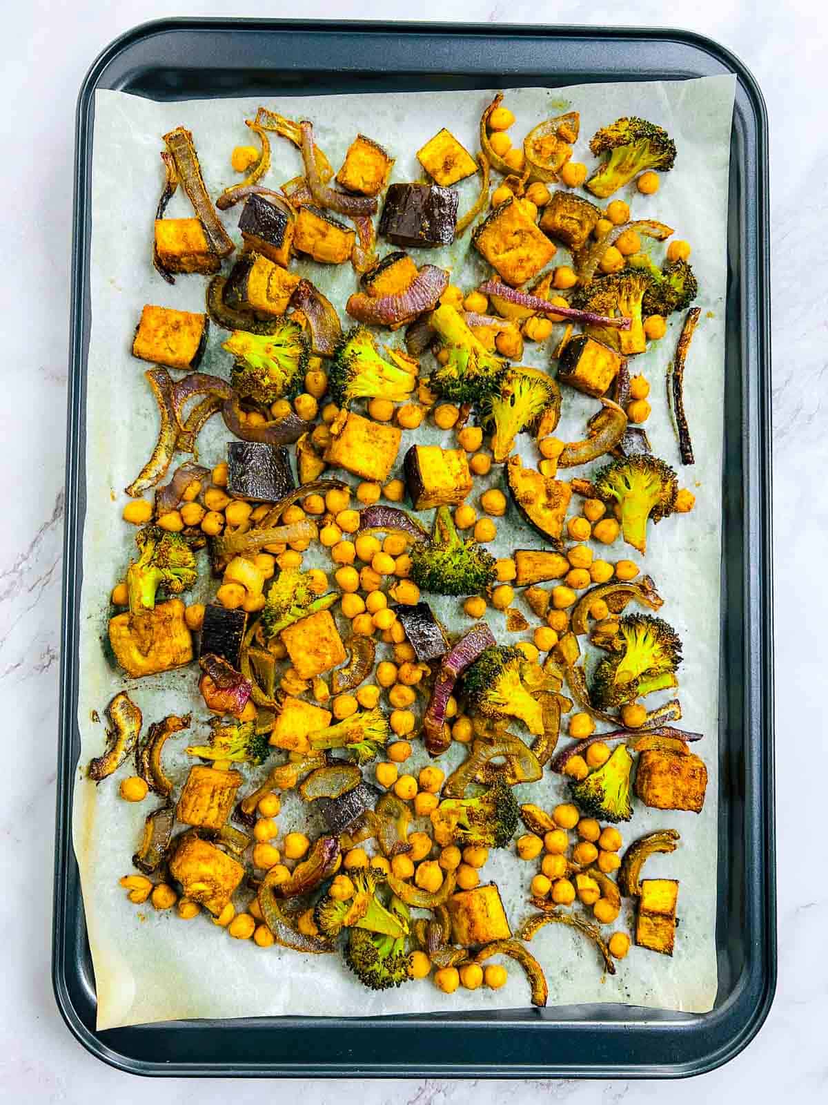 Roasted veggies and chickpeas on a baking sheet.