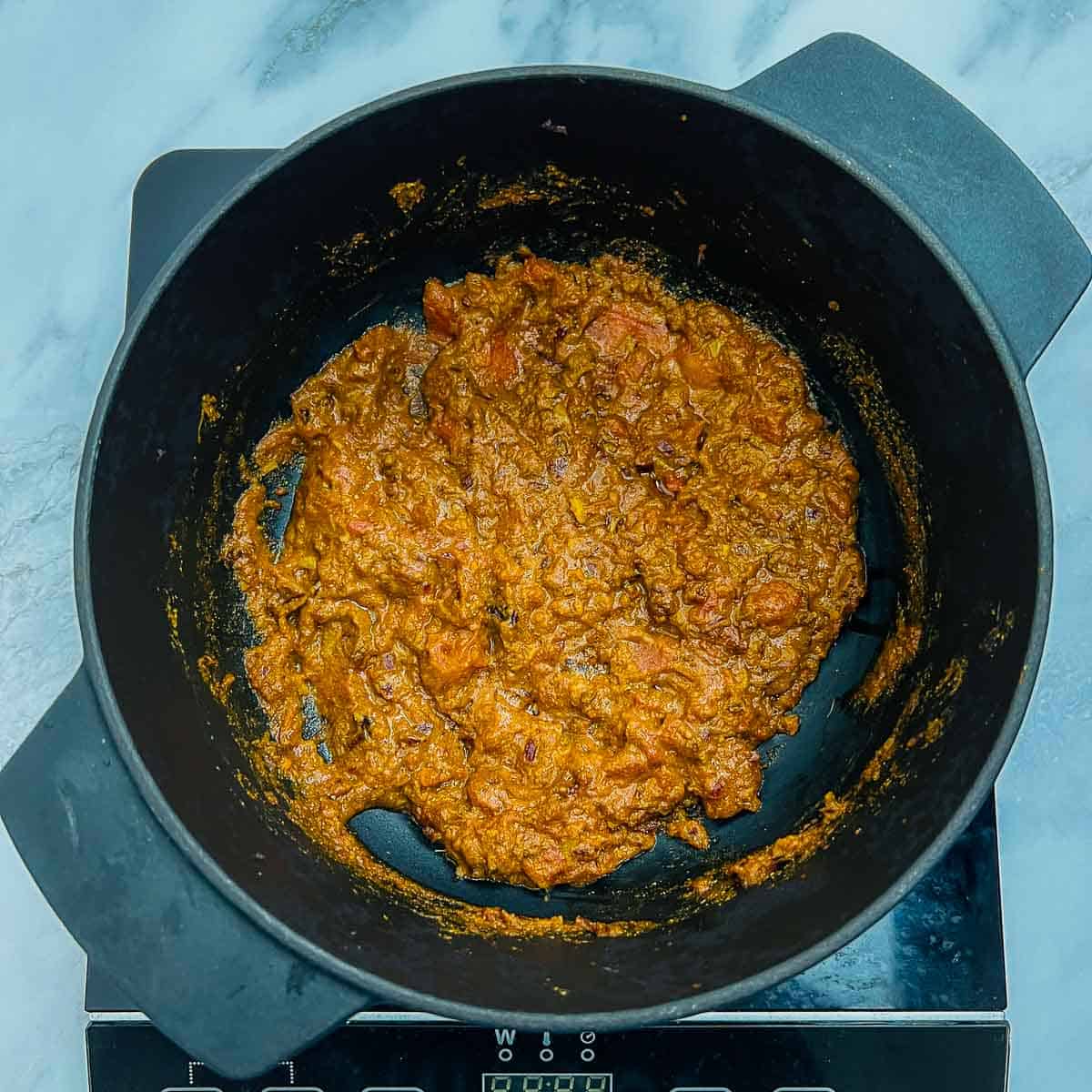 Tomato and spices cooked along with onions in the Dutch oven.