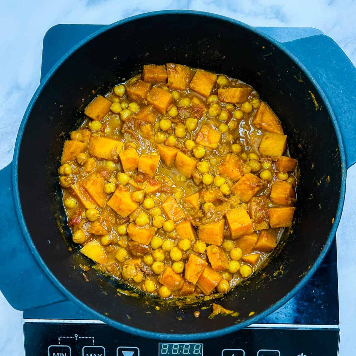 Cooked sweet potatoes and chickpeas with onion-tomato masala.