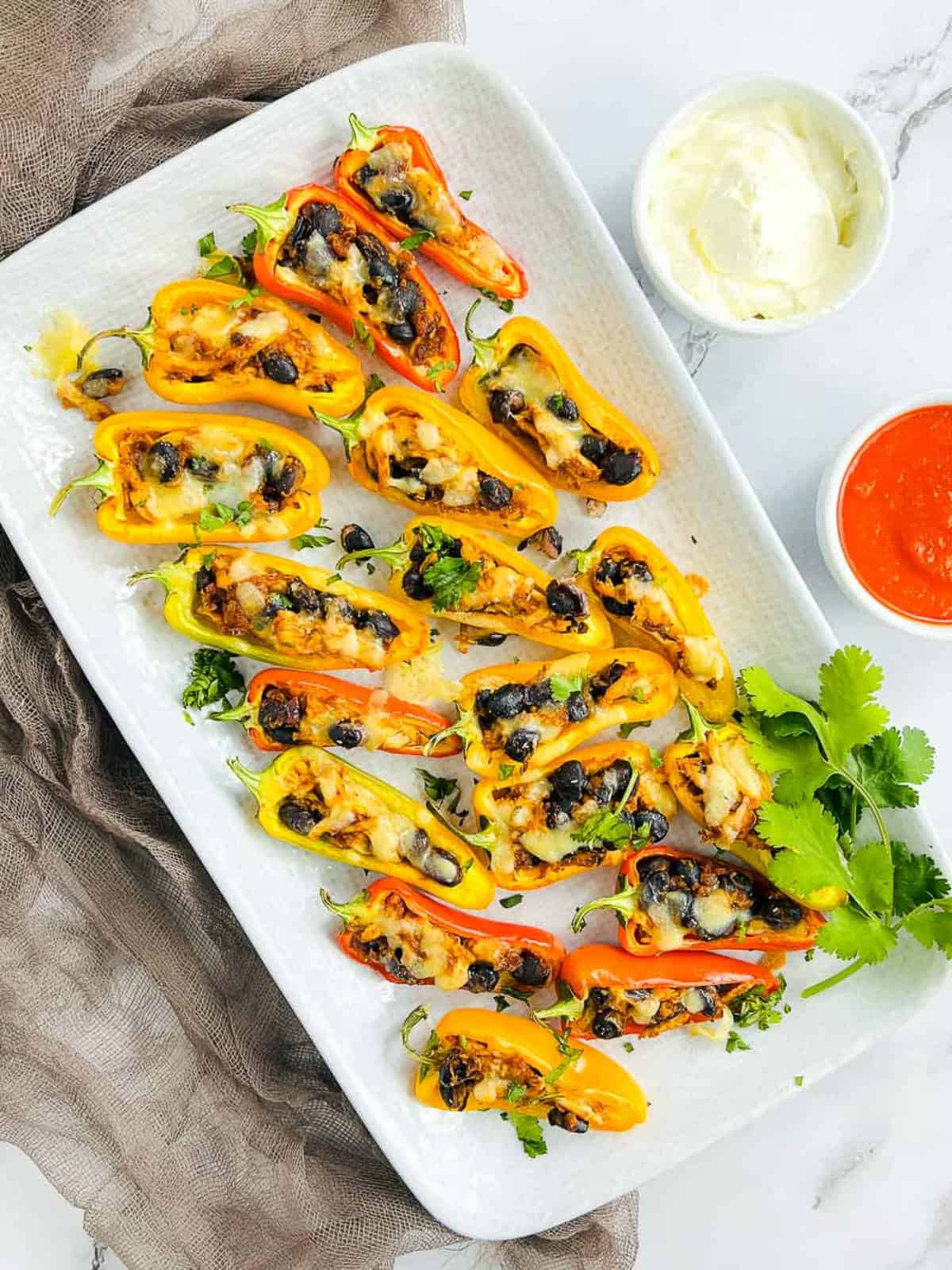 Chicken taco stuffed sweet peppers served with sour cream and hot sauce.