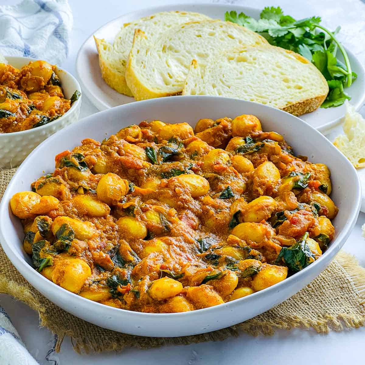 Side view of white bowl with curried butter beans.