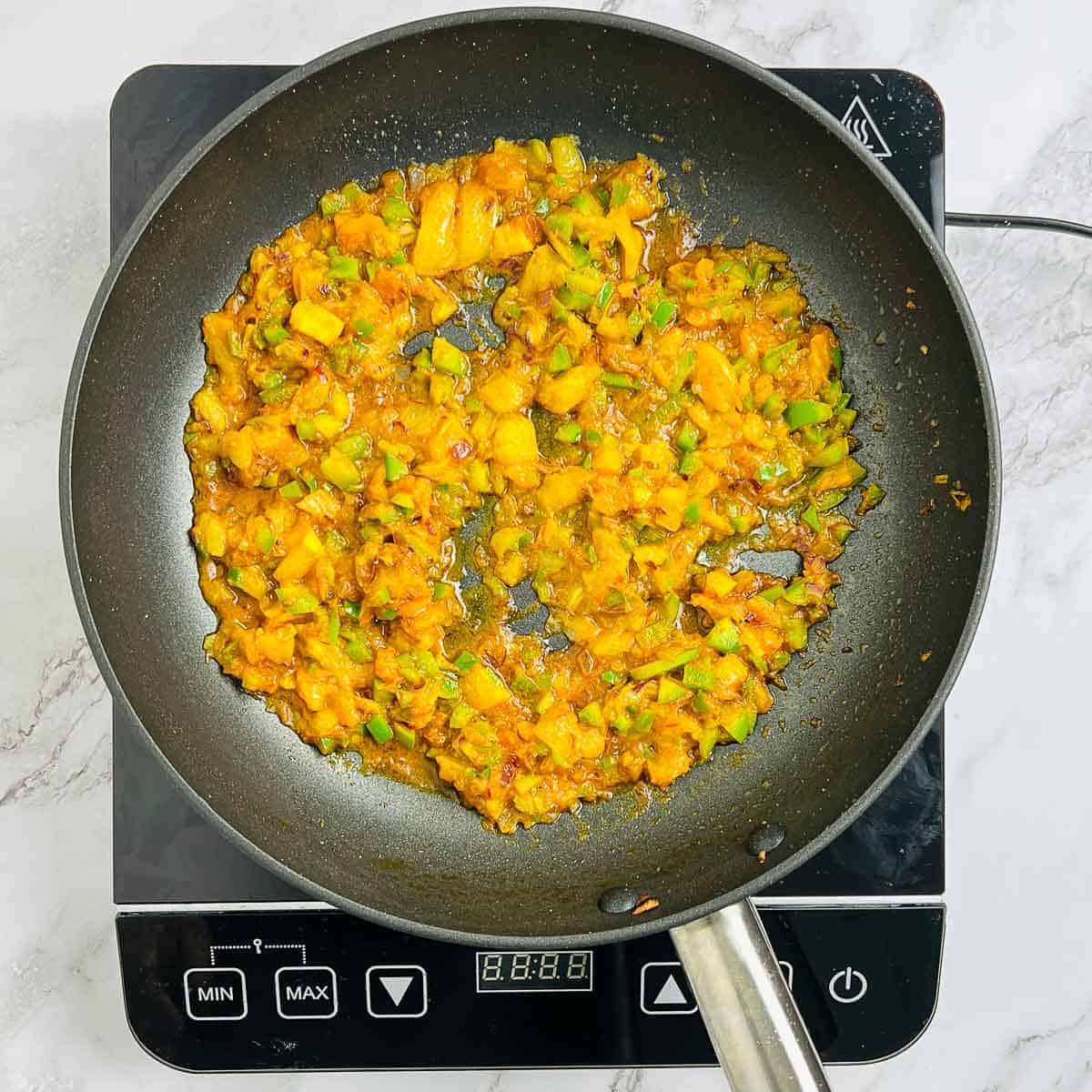 Sauted onion, tomatoes, and spices in a skillet.