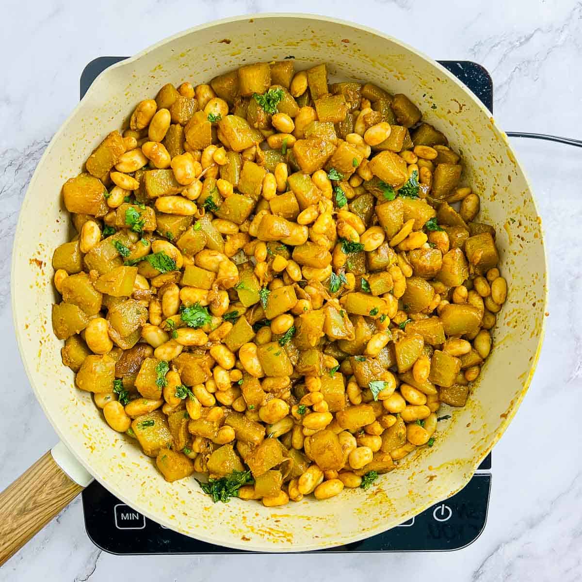 Cooked white beans in the squash garnished with cilantro.